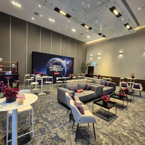 Lounge de un evento corporativo con pantalla de proyección y área de estar